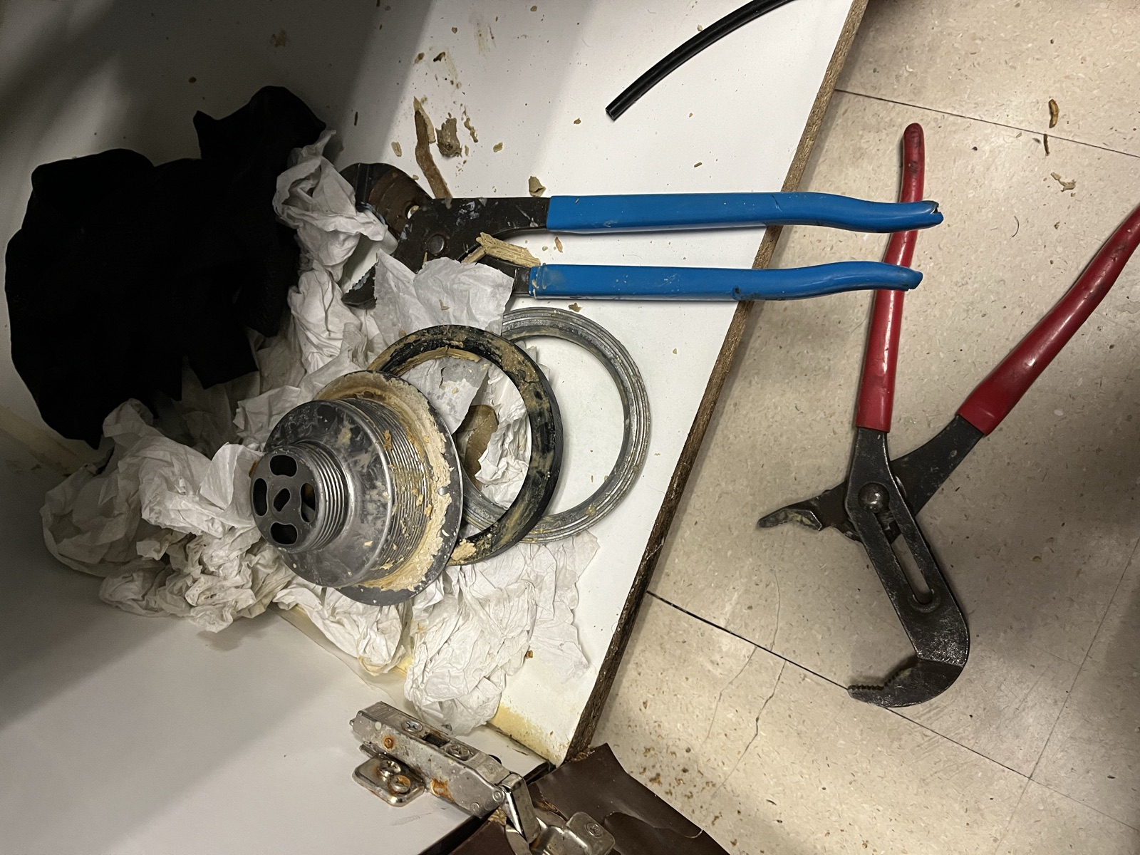 Sink drain repair with channel-lock pliers and replacement parts